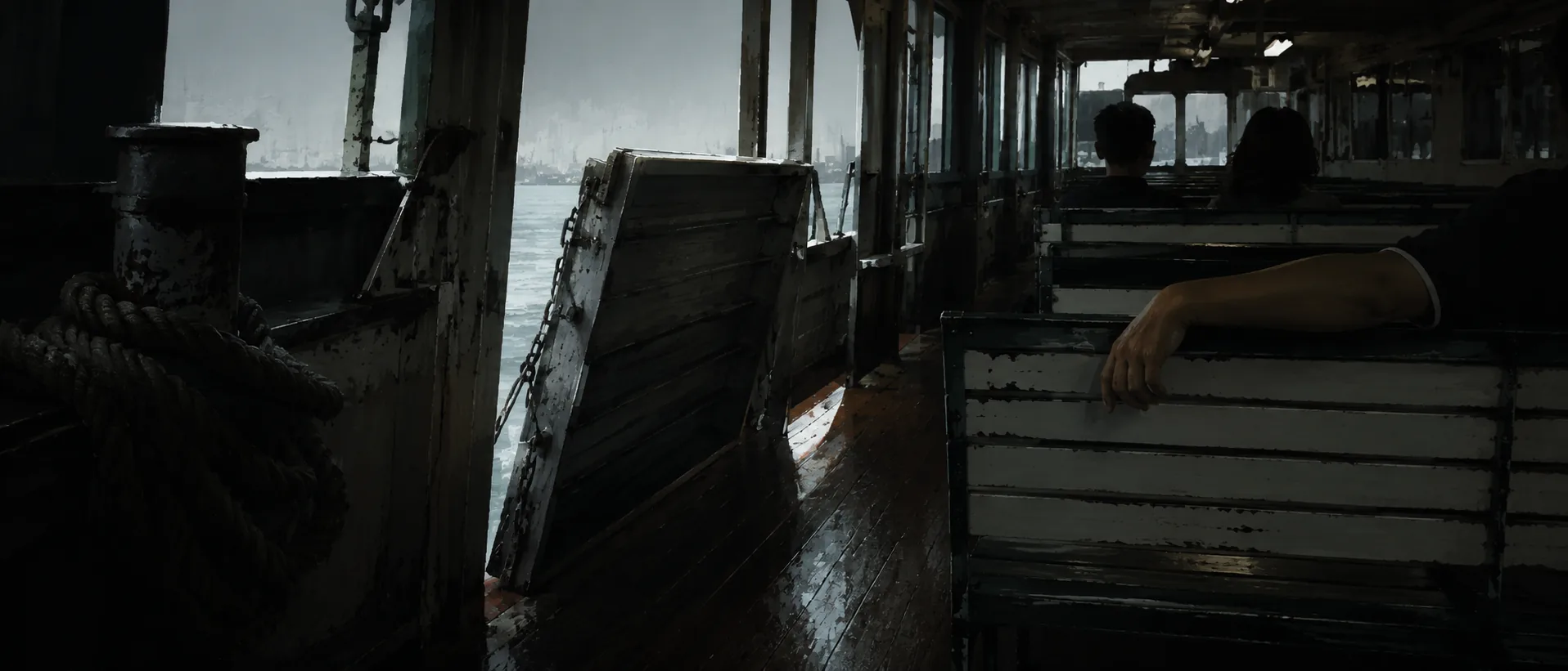 The Star Ferry's lower deck: slatted benches, a coiled rope and the raised gangway, the far shore grey through the opening